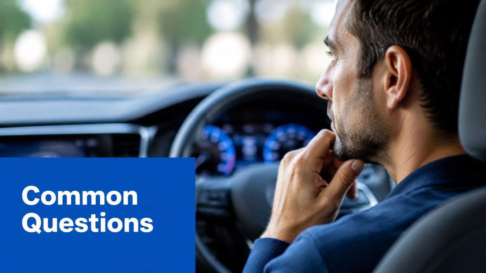 A pensive man sitting in the driver seat of a car while looking out the window.