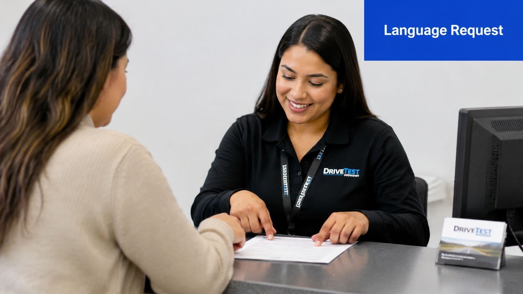 A smiling customer service representative at a DriveTest center assists a customer with official forms.